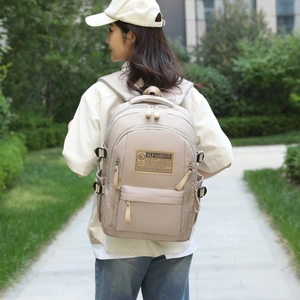 Large beige waterproof Oxford backpack shown on model in a minimalist outdoor setting