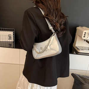 Silver shoulder bag with butterfly metal buckle and chain strap shown on model