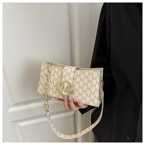 Close-up of cream square crossbody bag with M-letter print and gold chain handle