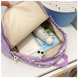Top view of spacious purple cartoon backpack interior with books and umbrella