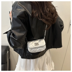 Silver quilted mini chain bag worn by model showing small size and metallic finish