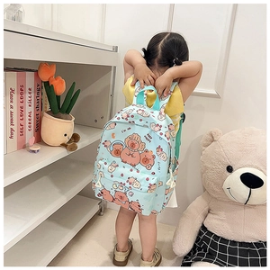 Detail of light blue backpack featuring cute capybara cartoon patterns and a front pocket