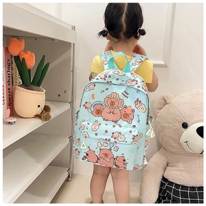 Rear view of a light blue cartoon backpack with cute bear and strawberry prints on a child