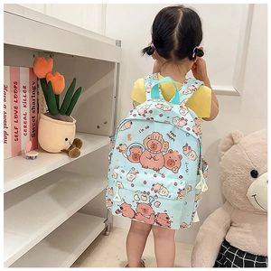 Detail of light blue school backpack with cute cartoon capybara prints and front pocket