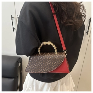 Close-up of vintage retro bag with gold twist handle and red leather shoulder strap