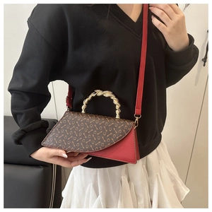 Detail of vintage leopard print crossbody bag with red leather side and gold twist handle