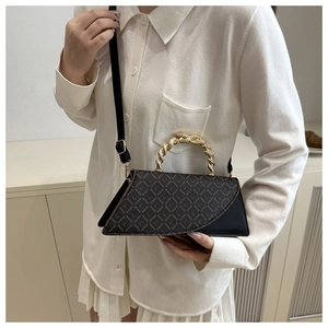 Detail of elegant leopard print crossbody bag with a twisted gold metal handle and leather strap