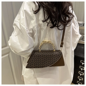 Detail of vintage coffee leather crossbody bag with chain print and twisted metal handle