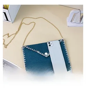 Sac enveloppe en denim bleu avec chaîne dorée et téléphone pour référence de taille réelle