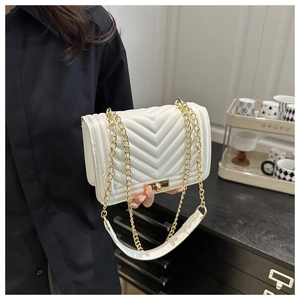 Détail du sac en similicuir blanc à surpiqûres en V avec chaîne dorée et fermoir pivotant