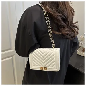 Détail du sac bandoulière blanc avec matelassage en V et chaîne dorée chic