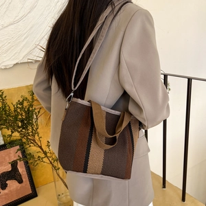 Retro striped canvas tote bag with top handles and shoulder strap shown in a lifestyle setting