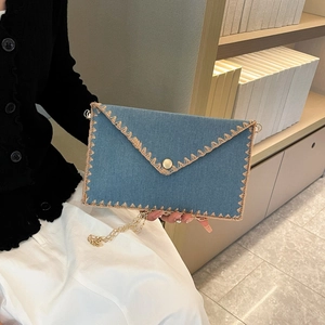 Sac bandoulière en denim bleu avec bordure en paille et chaîne dorée
