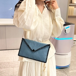 Sac bandoulière enveloppe en jean bleu clair avec chaîne dorée et pendentif à gland