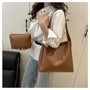 Detailed view of brown tote bag set with matching small pouch and smooth leather texture