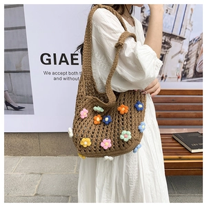 Close-up of a brown crochet tote bag featuring vibrant 3D knit flowers for summer style