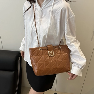 Brown quilted leather shoulder bag with gold geometric clasp and chain strap on model