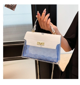 Detail of blue PVC quilted crossbody bag with white croc flap and gold twist lock