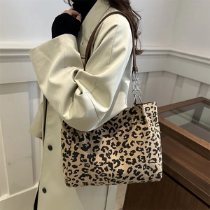 Sac cabas chic en velours côtelé léopard avec chaîne en métal porté par un mannequin