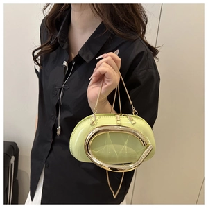 Détail du sac de soirée en cuir verni vert citron avec poignée dorée et bandoulière