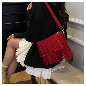 Détail du sac bohème rouge à franges en daim avec boucles métalliques dorées