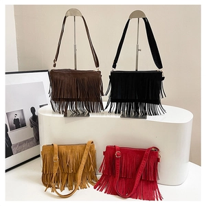 Détail des sacs à bandoulière à franges en marron noir jaune et rouge aspect suédine