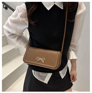 Detailaufnahme der braunen Ledertasche mit eleganter goldener Schleifen-Metallschnalle
