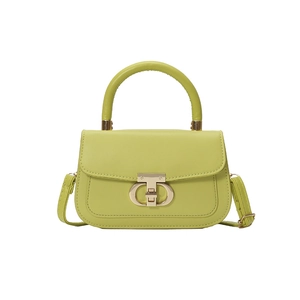 Avocado green leather handbag with matte gold lock and adjustable strap on white background