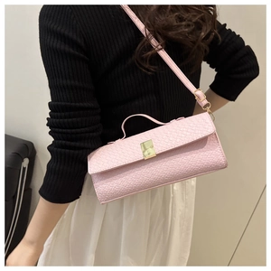 Detail of pink woven crossbody bag featuring a golden metal buckle and sleek leather strap