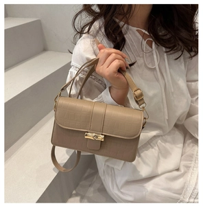 Dettaglio borsa beige a tracolla con stampa coccodrillo e chiusura in bambù oro