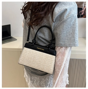 Close-up of dual-tone crossbody bag with black faux leather and woven straw texture