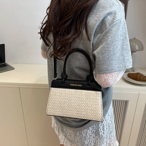 Chic straw woven crossbody bag with black leather accents and Fashion Bag text detail