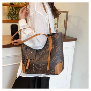 Détail d'un grand cabas vintage avec imprimé logo et mini pochette suspendue en cuir