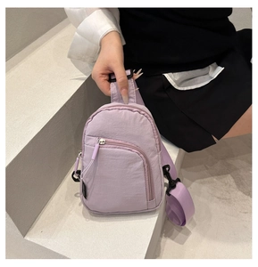 Détail du sac bandoulière en nylon lavande avec poches zippées et sangle ajustable