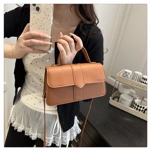 Brown leather crossbody bag featuring a minimalist V-shaped flap and top handle for women