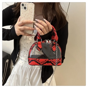 Detail of red and black snakeskin pattern shell bag with transparent PVC panel and chain