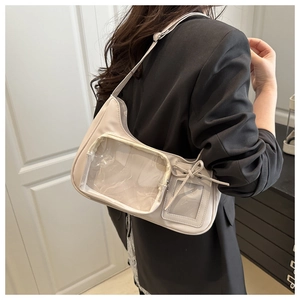Cremefarbene Ita-Bag aus Leder mit Sichtfenster und Schleife am Model getragen