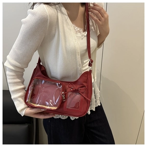 Détail d'un sac à bandoulière en cuir PU rouge avec poches PVC et décor de nœud doux