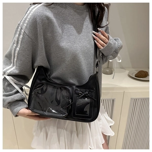 Detail of black ita bag featuring a large clear window and decorative bow for dolls