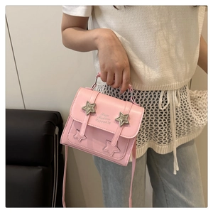 Detail of pink leather handbag with silver star studs and embroidered star patterns