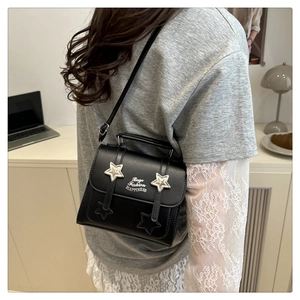 Close-up of black PU leather shoulder bag with silver star rivets and logo details