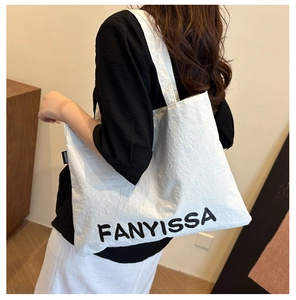 Close-up of the FANYISSA white tote bag showing the crinkle texture and logo print