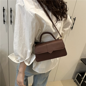 Brown leather crossbody bag with top handle and minimalist rectangular flap design