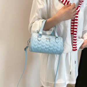 Sac à main bleu clair matelassé en forme de cœur avec nœud argenté et bandoulière