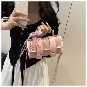 Sac bandoulière cylindrique rose avec texture paille et ruban décoratif en dentelle