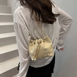 Floral embroidered straw bucket bag with gold chain strap and pearl drawstring details