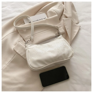 Detail of white faux snakeskin leather texture on a stylish baguette shoulder bag