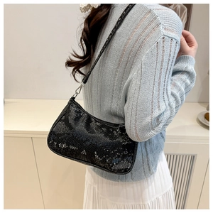 Close-up of black snake pattern shoulder bag with silver hardware on model