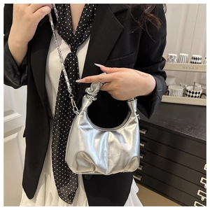 Detail der silbernen Metallic-Hobo-Tasche mit Faltenstruktur und schicker Metallkette