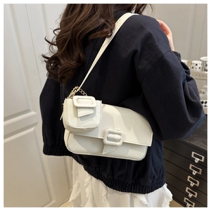 White lychee leather baguette shoulder bag with a matching mini pouch on a model's shoulder